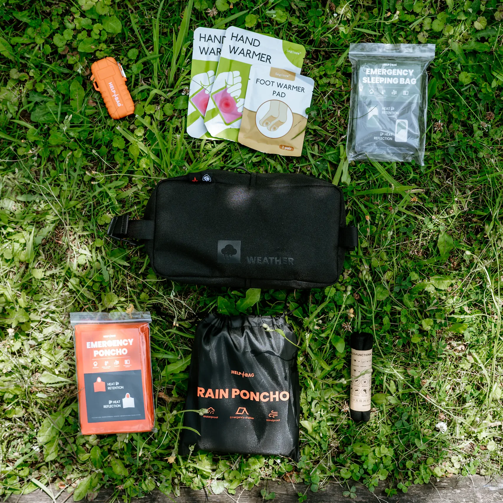 Moduł WEATHER HELP BAG z zawartością na trawie, w tym poncho przeciwdeszczowe w worku RAIN PONCHO