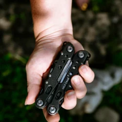 Złożony multitool HELP BAG ze stali nierdzewnej na otwartej dłoni, widać logo i wgłębienia