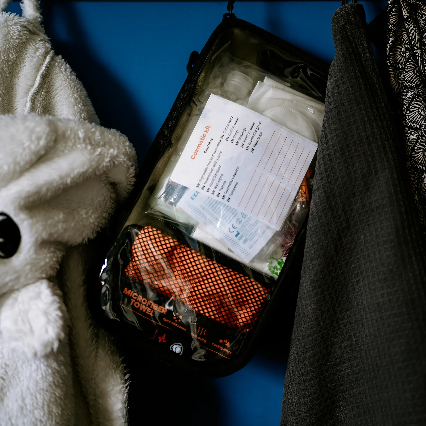 Moduł HYGIENE HELP BAG z ręcznikiem z mikrofibry i kosmetyczką zawieszony na wieszaku obok szlafroków