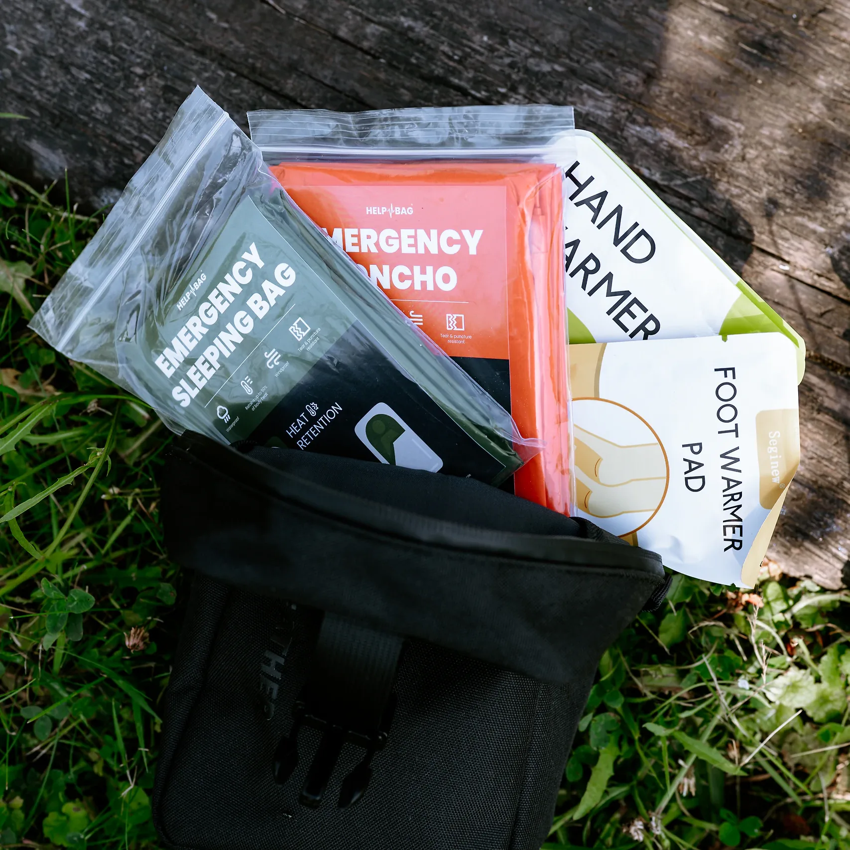 Śpiwór awaryjny HELP BAG wysuwa się z otwartego modułu WEATHER razem z poncho i ogrzewaczami