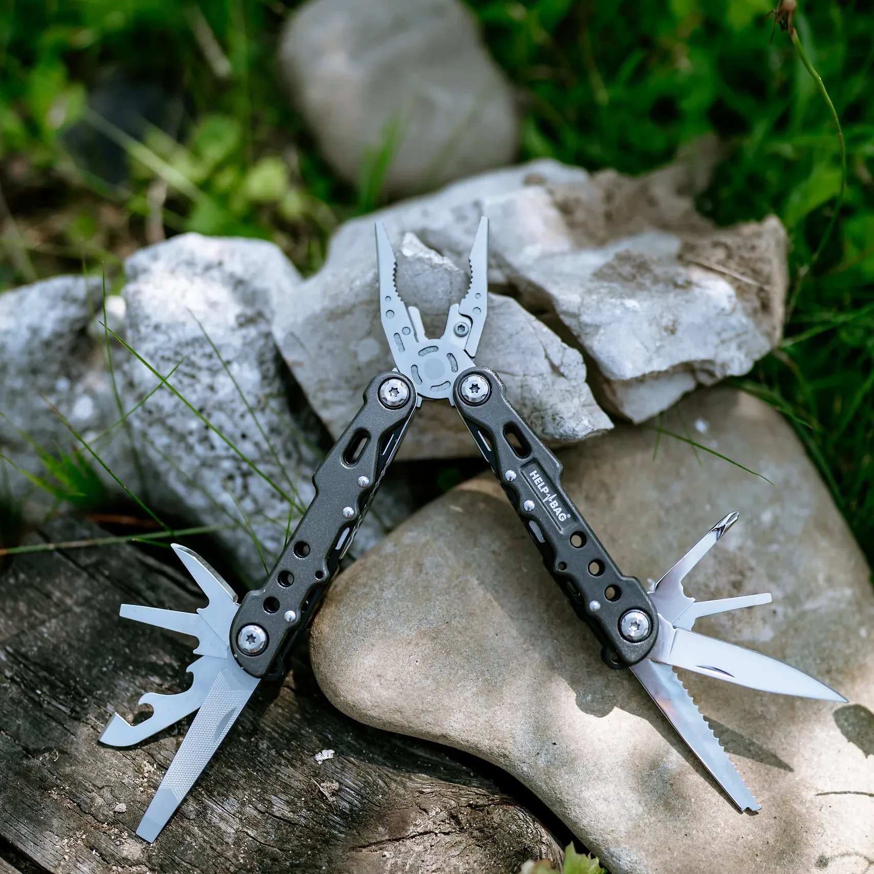 Rozłożony multitool HELP BAG na kamieniach, narzędzie z zestawu awaryjnego BASIC