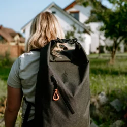 Zestaw awaryjny HELP BAG BASIC na plecach kobiety, wodoodporny plecak z pomarańczowym uchwytem zamka