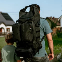 Tata z plecakiem HELP BAG MAX PRO z modułami na plecach idzie osiedlem obok syna