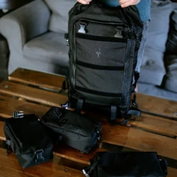 Plecak HELP BAG MAX PRO uniesiony nad stołem, obok odpięte moduły z klamrami